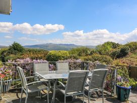 A seating area with a table and chairs overlooking a landscape at Bryn Y Mor, Borth Y Gest