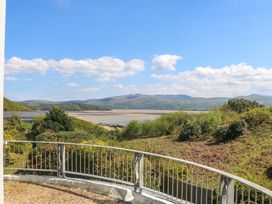 A view from a balcony overlooking hills and water at Bryn Y Mor, Borth Y Gest