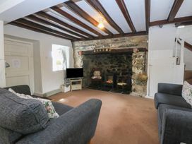 A living room with a fireplace and sofa at Y Bwthyn Criccieth