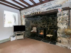 A living room with a television and fireplace at Y Bwthyn Criccieth