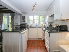 A kitchen with appliances and windows at Y Bwthyn Criccieth