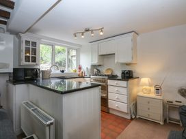 A kitchen with various appliances and cabinets at Y Bwthyn Criccieth