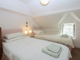 A bedroom with two beds and a window at Y Bwthyn Criccieth