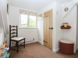 A hallway with a chair and door at Y Bwthyn Criccieth