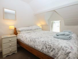 A bedroom with a bed and a bedside table at Y Bwthyn in Criccieth