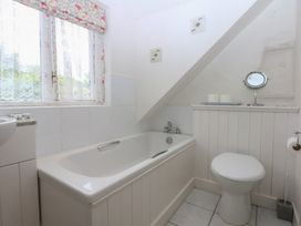 A bathroom with a bathtub and toilet at Y Bwthyn Criccieth