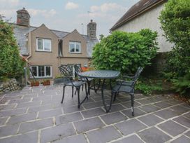 A garden with a table and chairs at Y Bwthyn Criccieth