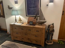 A hallway featuring a wooden chest with decorative items at Cae'r Dyni (Caer Dyni) Criccieth