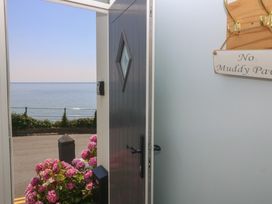 An entryway with a view of the ocean and flowers outside at Captain's Rest in Criccieth