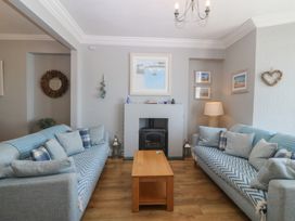 A living room with sofas and a coffee table at Captain's Rest in Criccieth