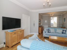 A living room with a television and sofa at Captain's Rest in Criccieth