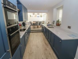 A kitchen with cabinets and appliances at Captain's Rest in Criccieth