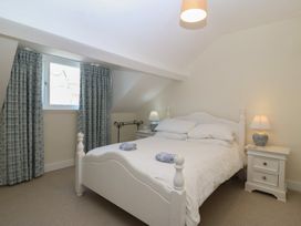 A bedroom with a bed and curtains at Captain's Rest in Criccieth