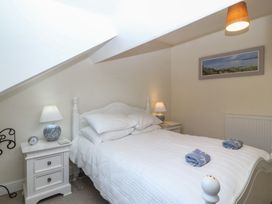 A bedroom with a bed and nightstand at Captain's Rest in Criccieth