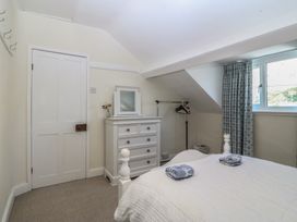 A bedroom with a bed and dresser at Captain's Rest in Criccieth