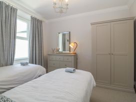A bedroom with two beds and furniture at Captain's Rest in Criccieth