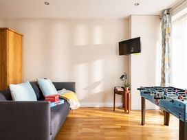 A living room with a sofa and a foosball table at Coed y Felin in Conwy