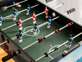 A foosball table with blue and red players at Coed y Felin Conwy
