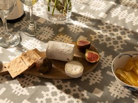A dining room table setting with wine glasses, cheese, crackers, figs and potato chips at Coed y Felin Conwy