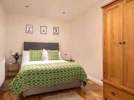 A bedroom with a bed and wardrobe at Coed y Felin in Conwy