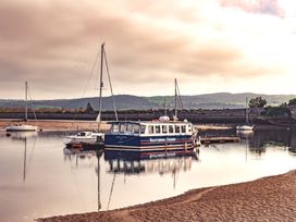 A boat and sailboats moored in a harbor at Coed y Felin in Conwy