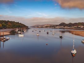 A view of boats on a river with hills in the background at Coed y Felin, Conwy