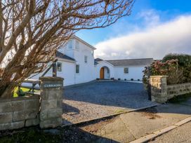 A house with a gravel driveway and gate at Curragho in Trearddur Bay