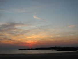 A sunset over the water with clouds at Curragho in Trearddur Bay