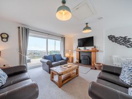 A living room with a sofa and television at Curragho in Trearddur Bay