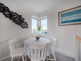 A dining room with a table and chairs at Curragho in Trearddur Bay