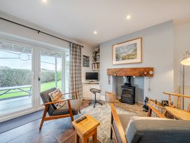 A living room with a fireplace and television at Curragho, Trearddur Bay