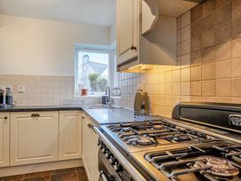A kitchen with sink and stove at Curragho in Trearddur Bay