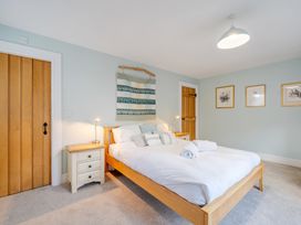 A bedroom with a bed and bedside table at Curragho in Trearddur Bay