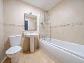 A bathroom with shower, bathtub, sink, and toilet at Curragho in Trearddur Bay