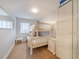 A bedroom with a bunk bed and wardrobe at Curragho in Trearddur Bay