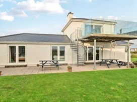 A building with a deck and stairs at Curragho in Trearddur Bay