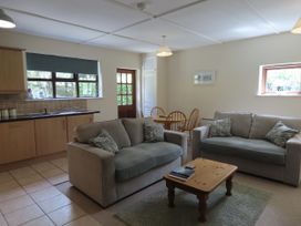 A living room with a sofa and table at Bryn Eira Tack Room Llanfair PG