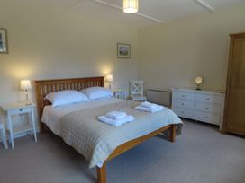 A bedroom with a bed and nightstands at Bryn Eira Tack Room in Llanfair PG