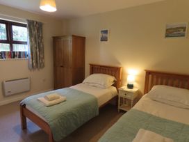A bedroom with two beds and a nightstand at Bryn Eira Tack Room Llanfair PG