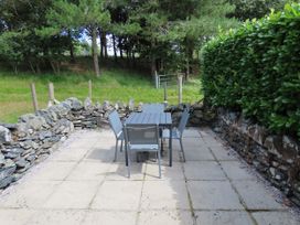 A patio with a table and chairs at Bryn Eira Tack Room Llanfair PG