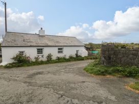 A house with windows and door near a road at Farm Cottage in Cemaes Bay