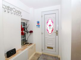 An entrance with a door and coat hooks at Farm Cottage in Cemaes Bay