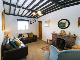 A living room with sofas and a fireplace at Farm Cottage in Cemaes Bay