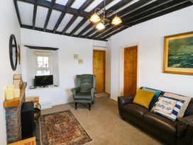 A living room with a sofa and television at Farm Cottage in Cemaes Bay