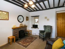 A living room with a fireplace and sofa at Farm Cottage in Cemaes Bay