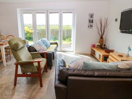 A living room with a sofa and chairs at Farm Cottage in Cemaes Bay