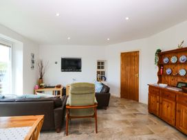 A living room with a sofa and television at Farm Cottage in Cemaes Bay