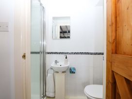 A bathroom with a shower, sink, and toilet at Farm Cottage in Cemaes Bay