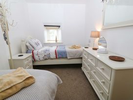 A bedroom with two beds and a dresser at Farm Cottage in Cemaes Bay