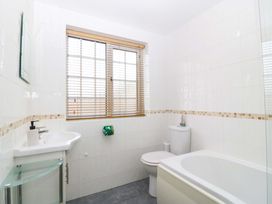 A bathroom with a sink bathtub and toilet at Farm Cottage in Cemaes Bay